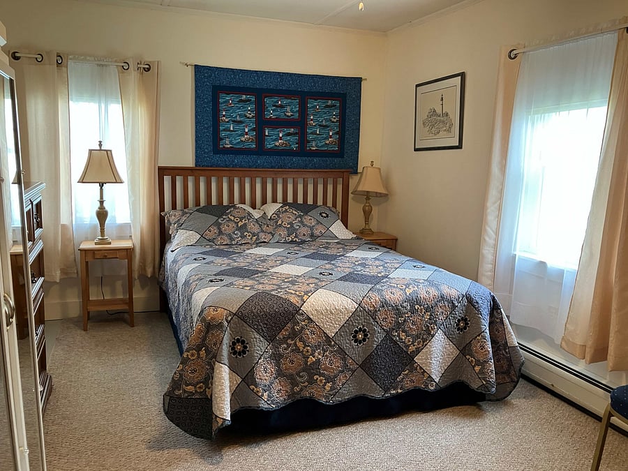 Second bedroom with queen bed. It has a free standing wardrobe and shelves. The closet area contains the washer/dryer.