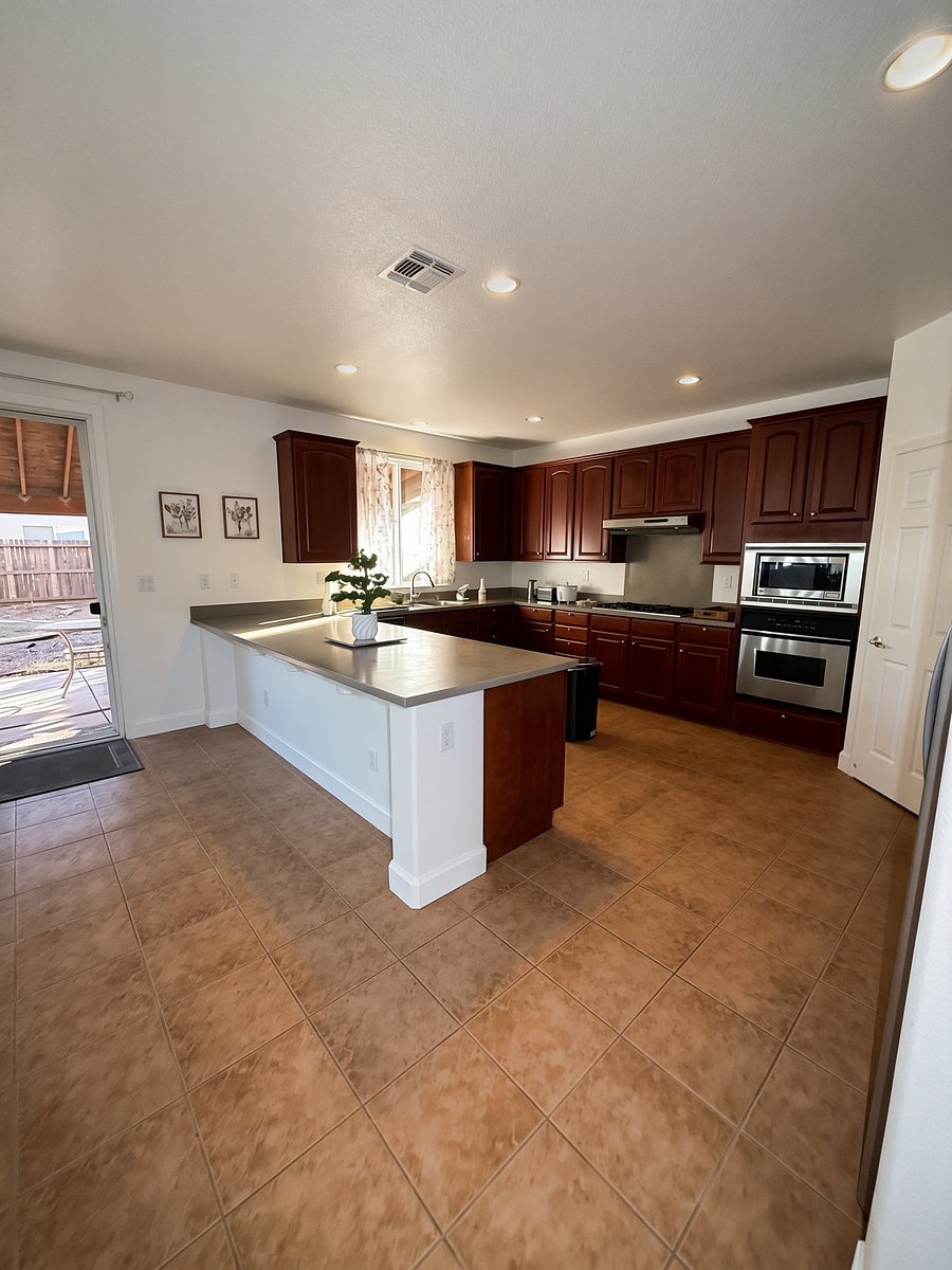 Eat-in kitchen (stools have been added) w/stainless steel appliances