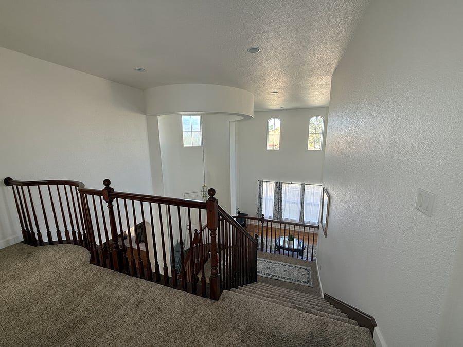 Top of the staircase and catwalk to primary suite (to the left)