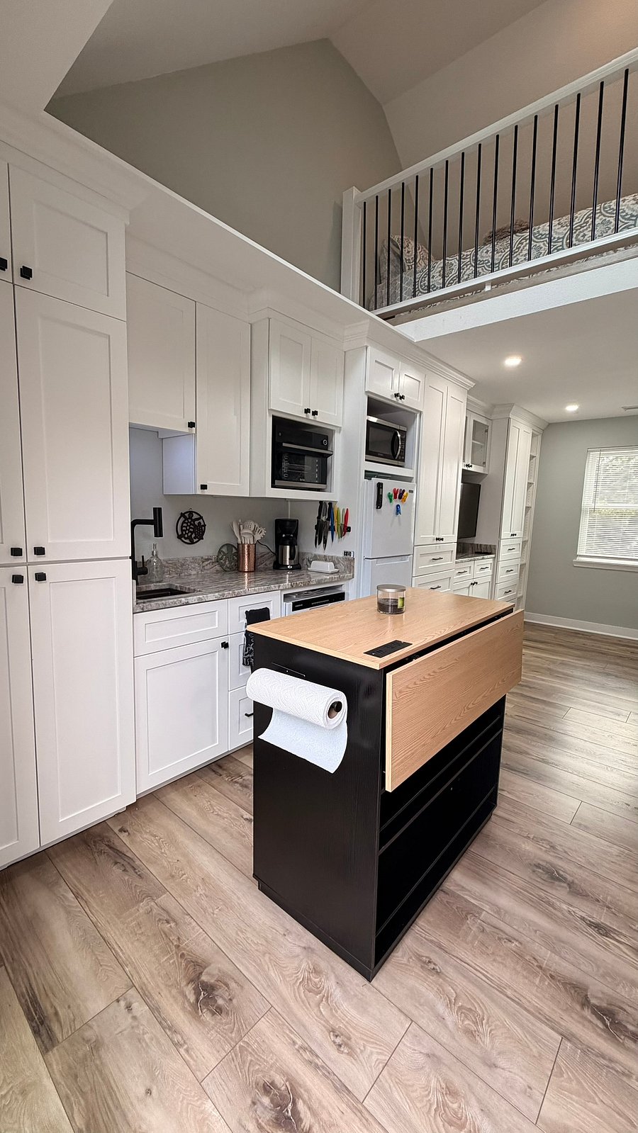 Fully functional kitchenette. The kitchen island moves to create more space, and the back panel adjusts up for more cooking/eating space. Kitchen comes with an air fryer oven, fridge, dishwasher, microwave, and induction cooktop. (Washer and dryer too)
