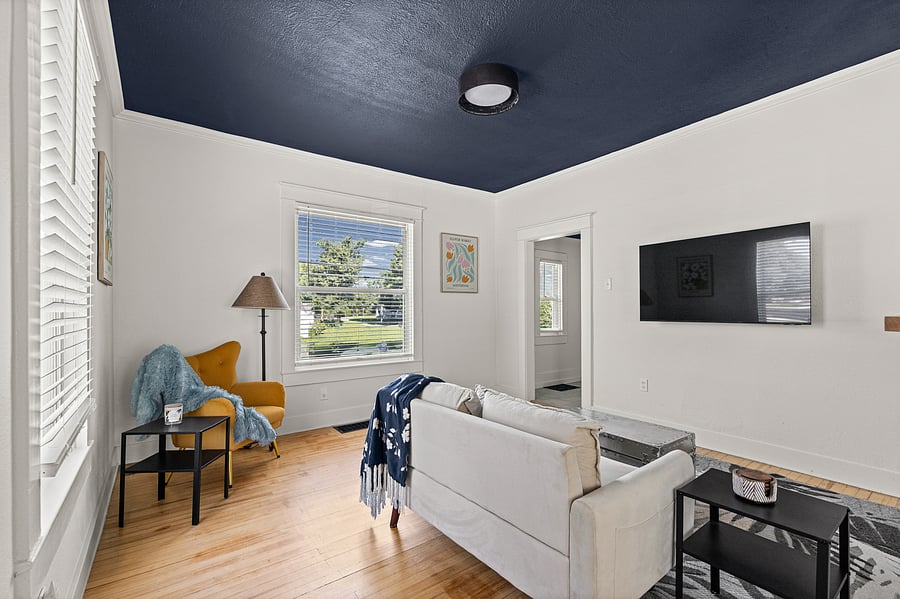 This living area is just off the back porch and features smart tv, couch, reading nook, and plenty of natural light.