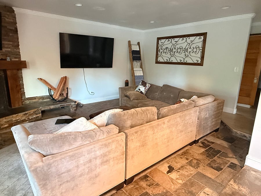 Living room with wood burning fireplace connected to kitchen.