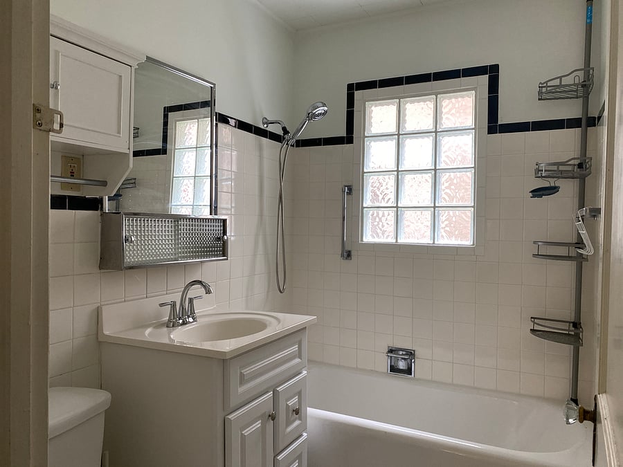 Clean and re-grouted floor and wall tile grout. Reglazed original bathtub. New faucet and showerhead sprayer, shower organizer.