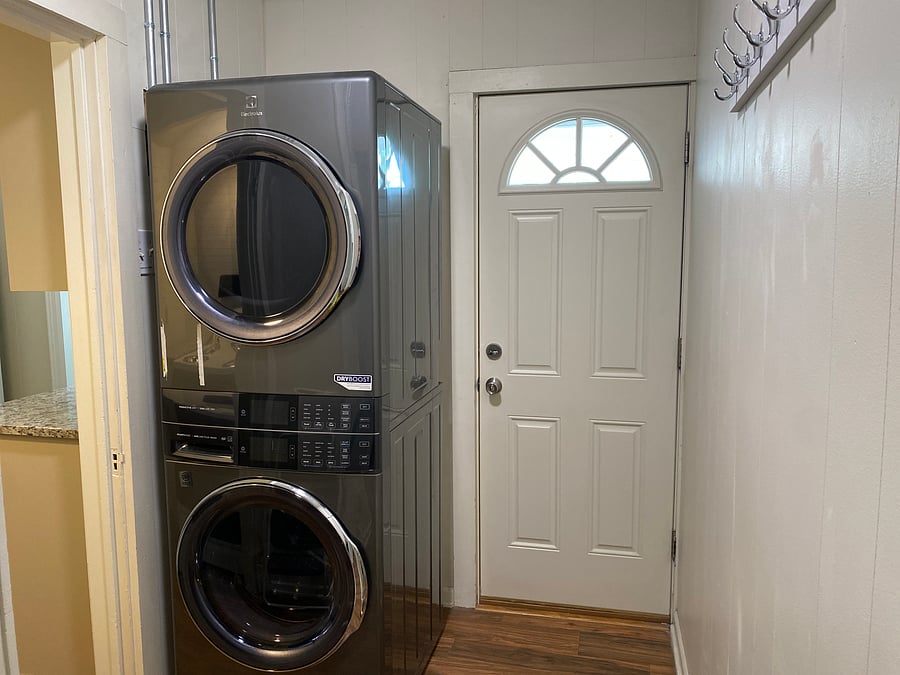 Utility room with back door entrance for access to garbage and recyclable. Hooks to hang coats, purses, etc. New Electrolux stackable washer/dryer with steam and wrinkle release option. Predictive dry and smart boost. Access one to office/workspace.