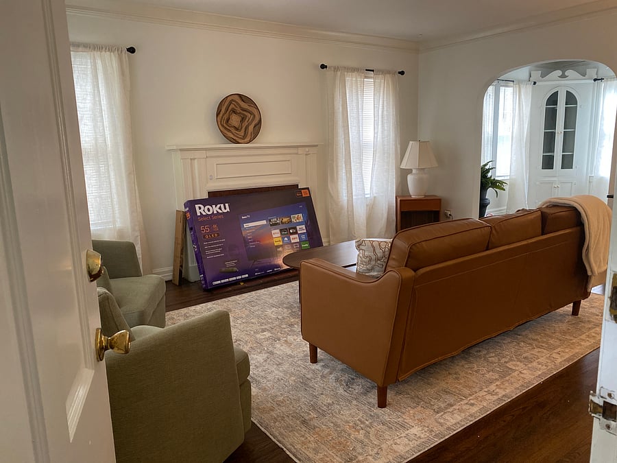 Main living area with Roku TV to be installed. Leads into the dining room then to kitchen.