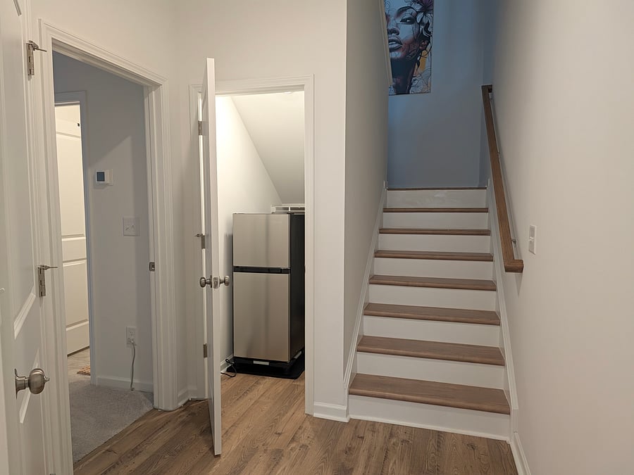 Hallway outside the suite showing additional closet storage and private use refrigerator.
