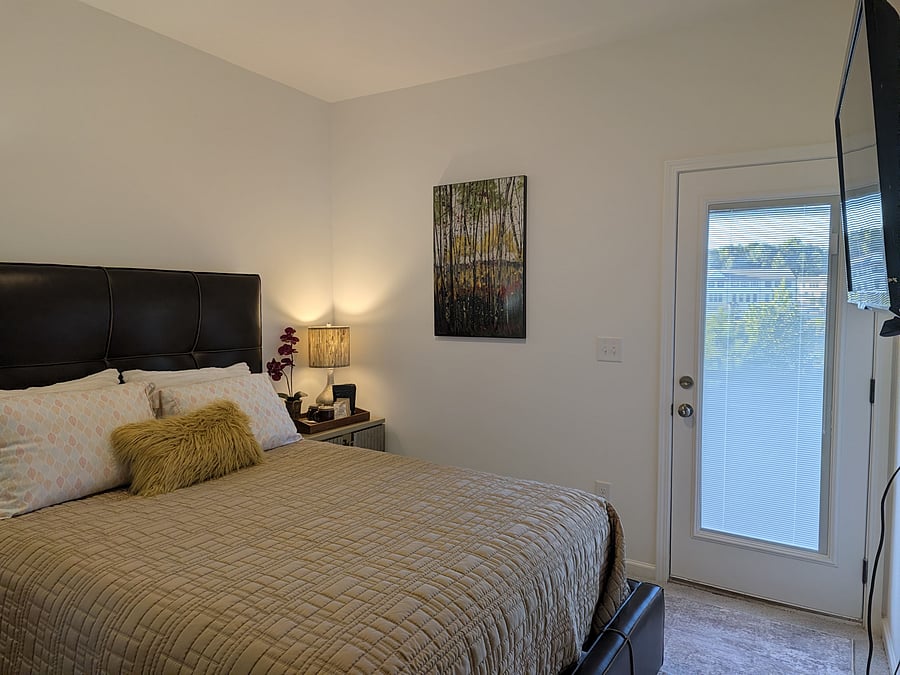 bedroom view from the desk area with exterior door closed.