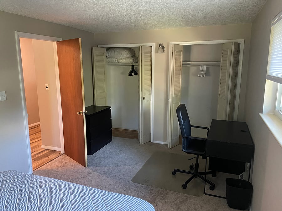 Main floor bedroom #2 showing dresser, desk and clothes closets
