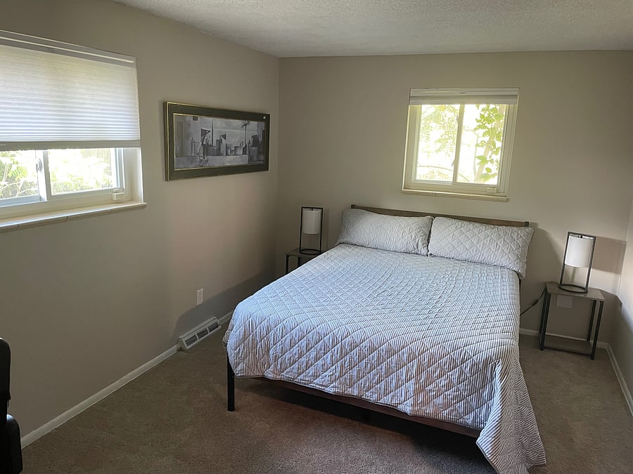 Main floor bedroom #2 with Purple queen bed, dresser, desk and two clothes closets