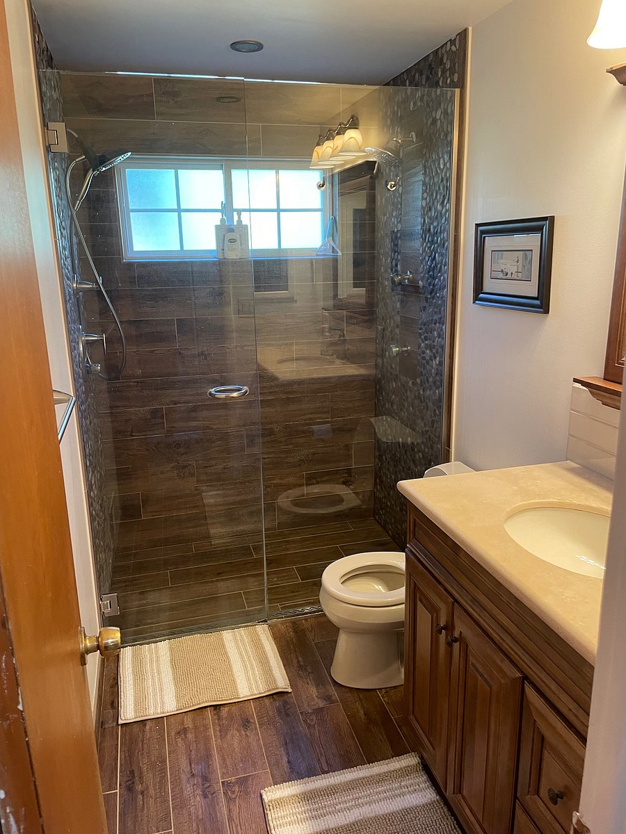 Main floor bathroom with walk in shower offering two shower heads and body sprays, toilet and one sink vanity.