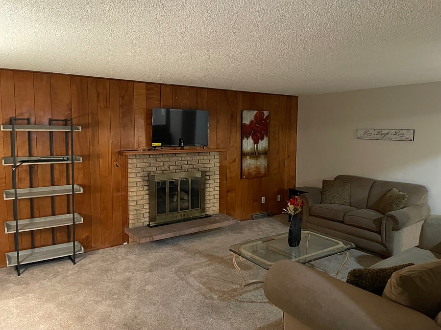 Livingroom with couch, love seat, smart TV and book shelf
