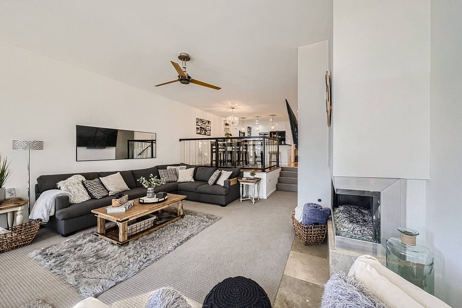 The living area includes a modern ceiling fan, complementing the home's bright and airy design.