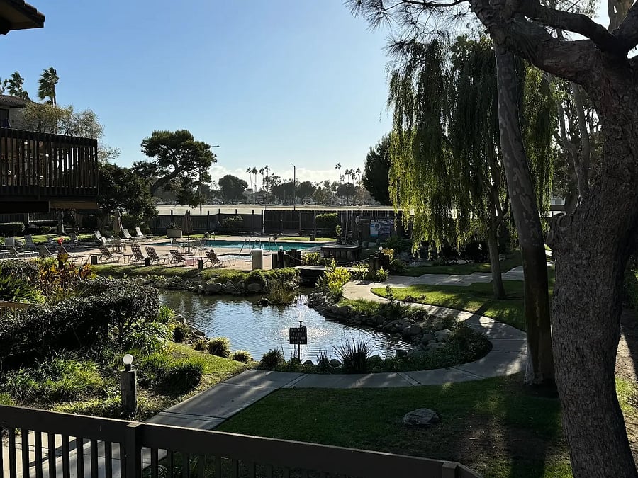 The property is set within a beautifully landscaped community featuring mature trees, lush greenery, and peaceful walking paths.