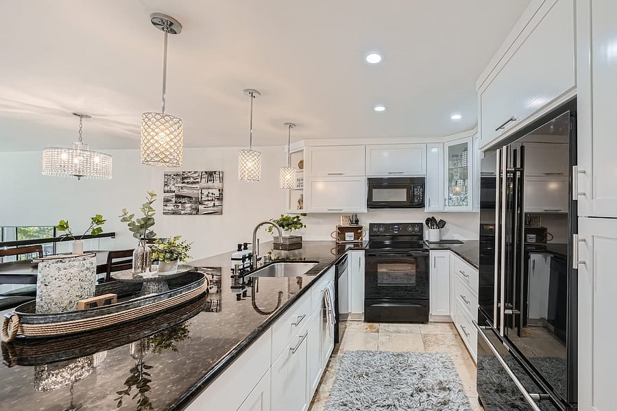 The kitchen includes a full range of appliances, including a refrigerator, oven/range, microwave, dishwasher, and generous cabinetry and counter space.