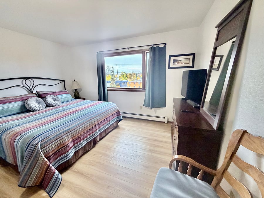     Relax in the spacious primary bedroom featuring a California king bed and Smart TV.