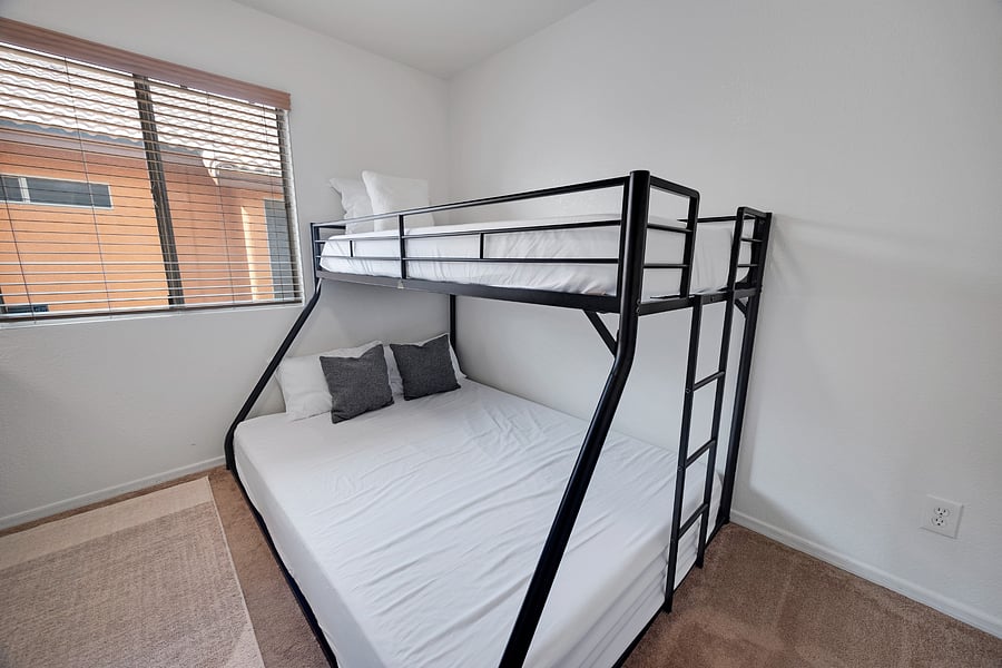 Thoughtfully arranged bunk bedroom with a queen-size lower bed and twin upper bed, ideal for flexible family sleeping arrangements.