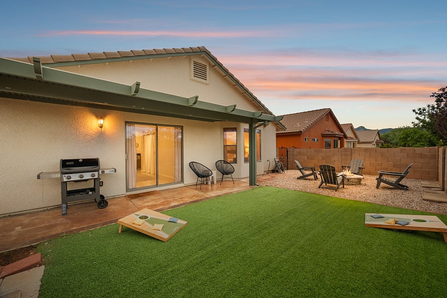Enjoy evenings outdoors with a covered patio, BBQ grill, cornhole, and fire pit in the fully fenced backyard.