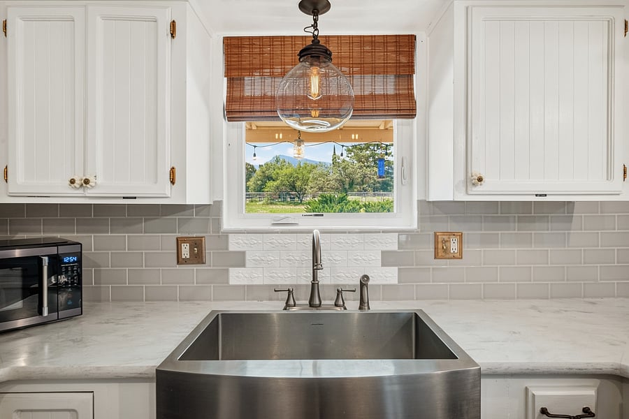 Bright kitchen sink area with a window overlooking the outdoor surroundings.