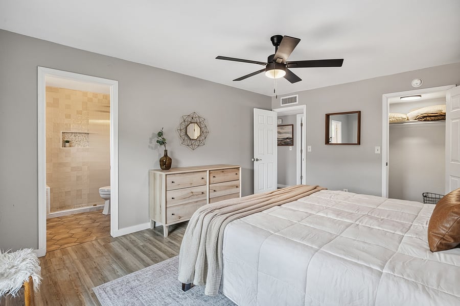 Spacious primary bedroom with a ceiling fan and room to unwind and settle in.
