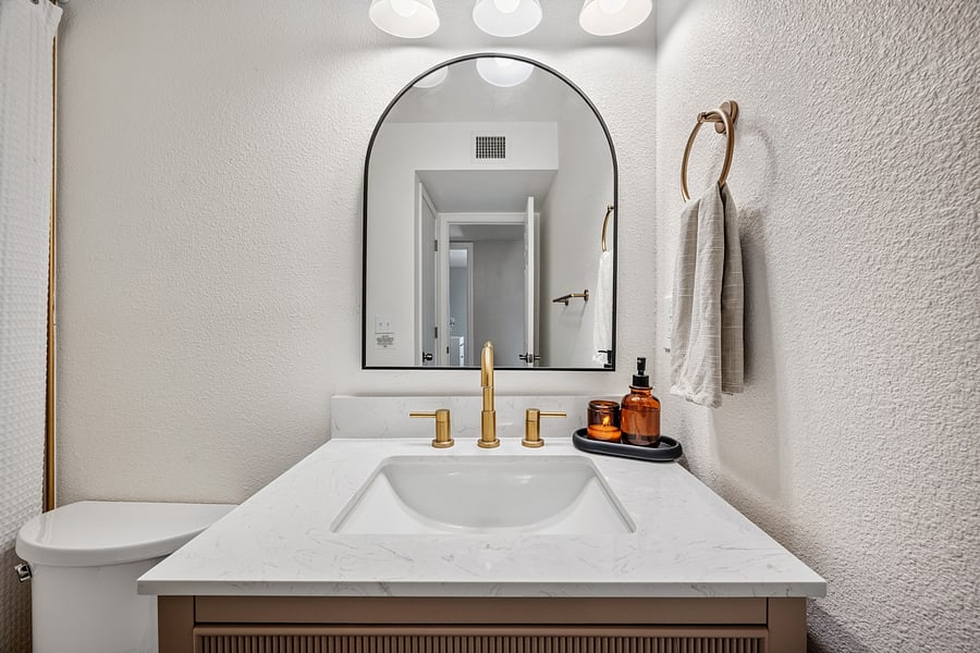 Bright guest bathroom with a vanity and mirror, conveniently serving the additional bedrooms.