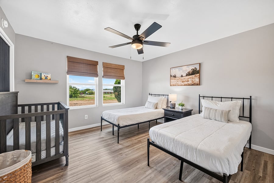 Third bedroom with two twin beds and a crib, offering flexible sleeping arrangements for families.