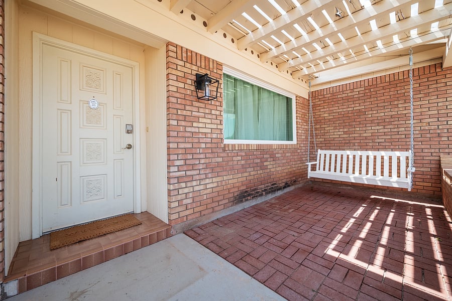 Covered front porch with a hanging swing offers a peaceful spot for coffee or an evening break.