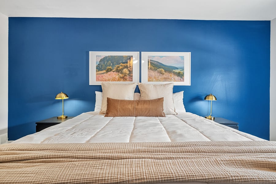 Comfortable king-size bed with bedside lighting, ideal for restful nights during longer visits.