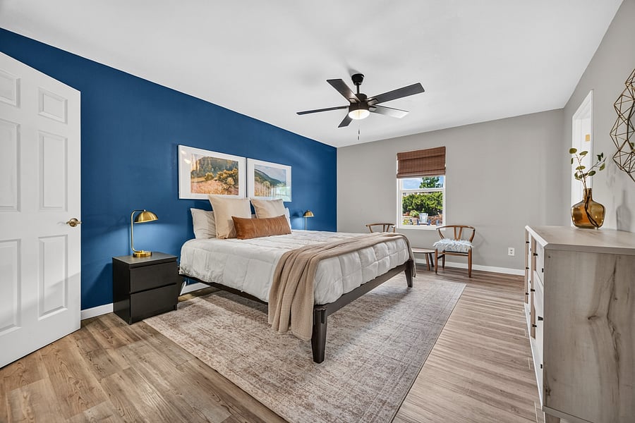 Private primary bedroom with a king-size bed, calming blue accent wall, and attached bathroom.