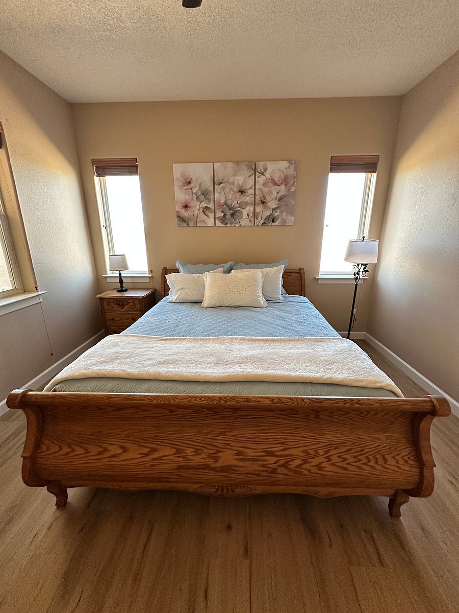 Kingsize bed in the master bedroom. View of open space behind house.