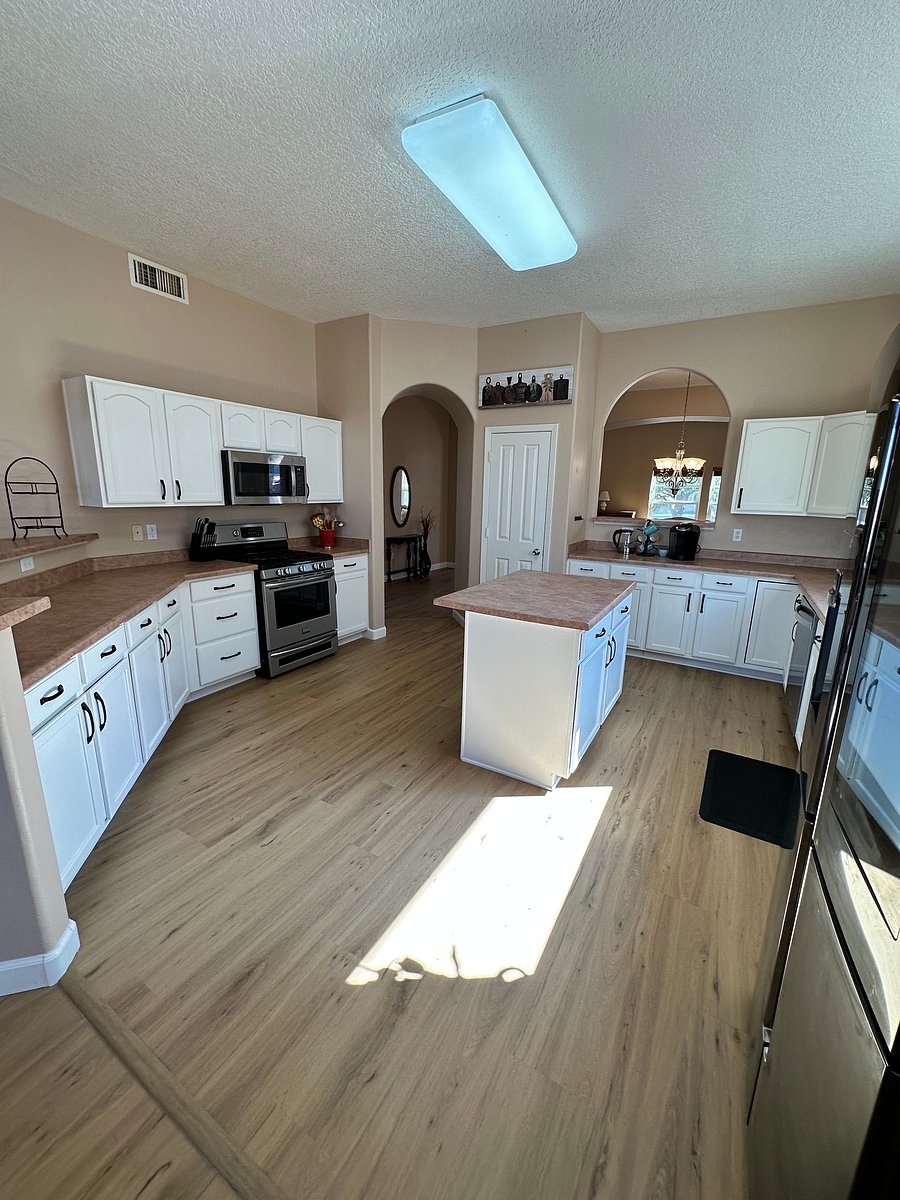 Very large kitchen with microwave, diswasher, and stove/oven. Lots of cupboards to store kitchen essentials. Tall metal garbage can is in the pantry. Kitchen is stocked with the basics.