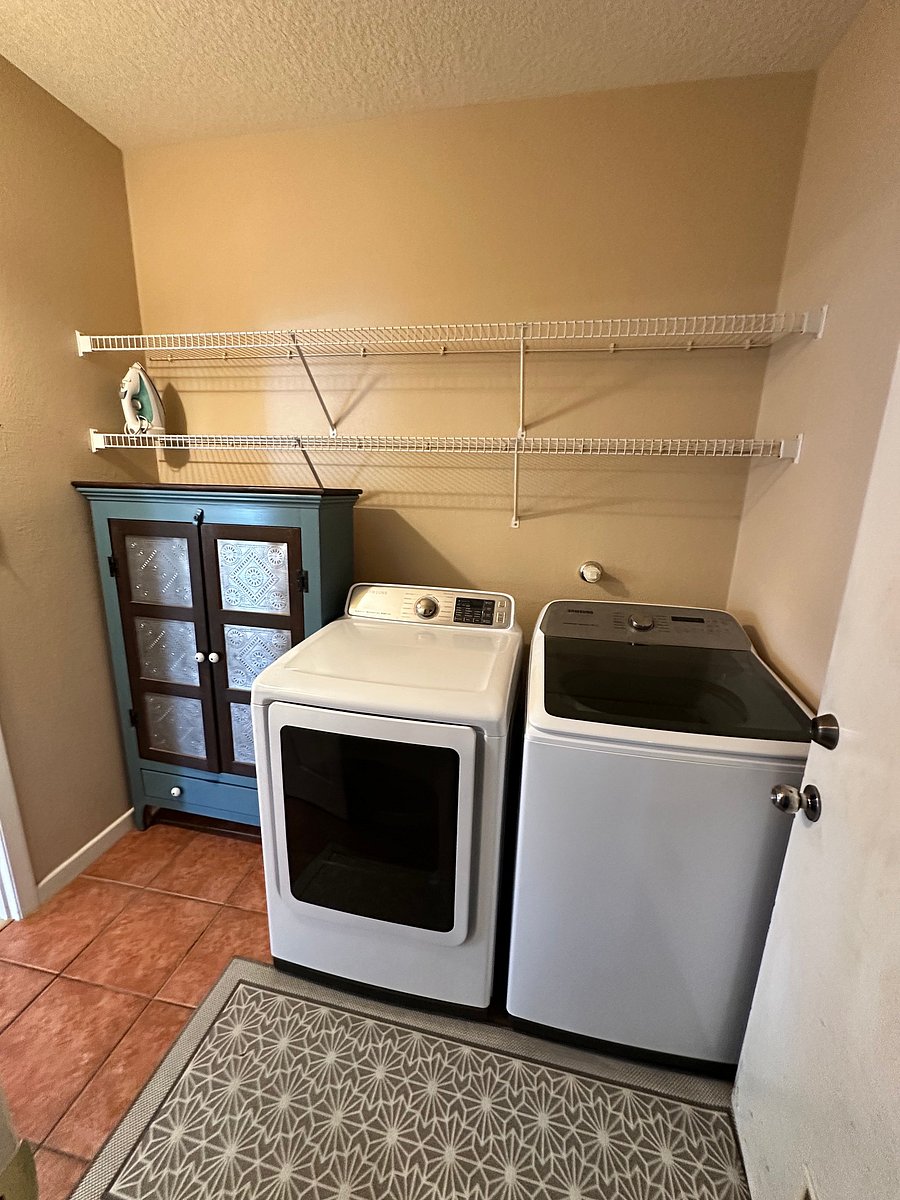 Laundry room. There is an ironing board available that is hanging behind the door.