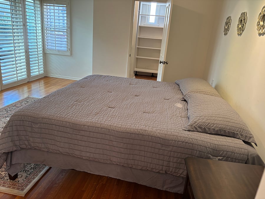 a king bed, a walk-in closet, an attached private full bathroom with bathtub, shower, and a double vanity