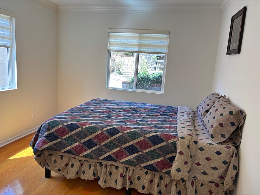 a queen bed, corner closet, attached full bathroom with a shower