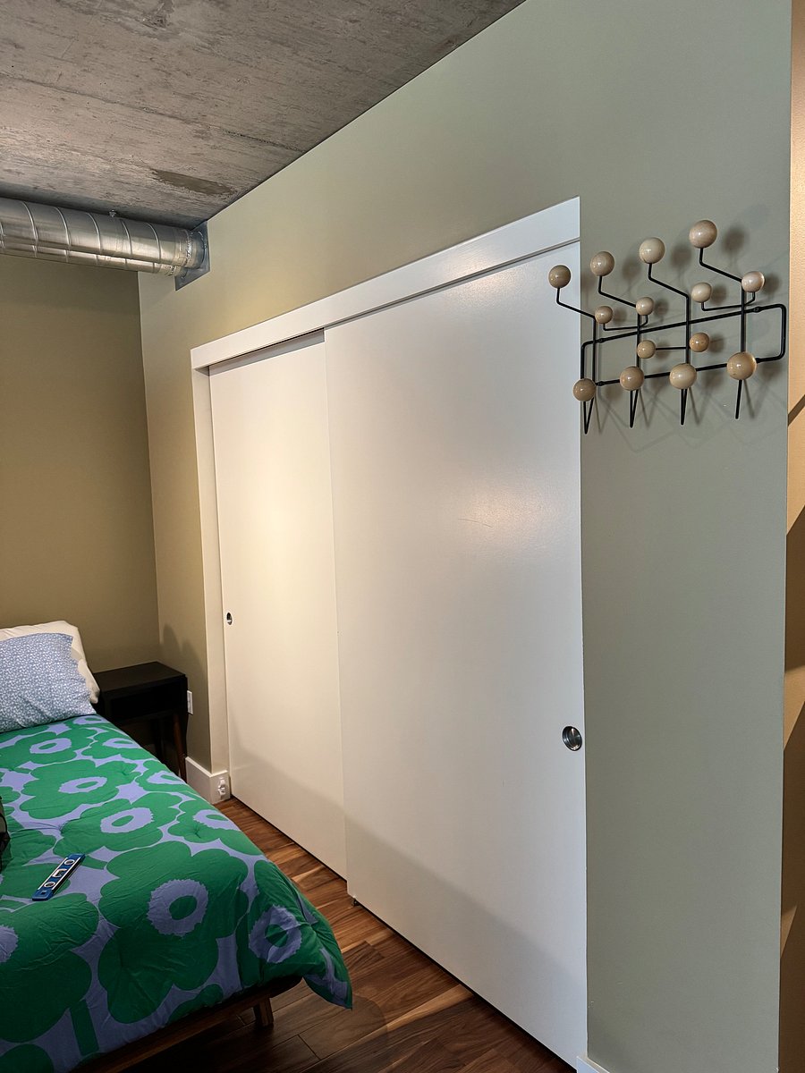 Eames Hang-It-All ball coat hanger next to closet in bedroom.