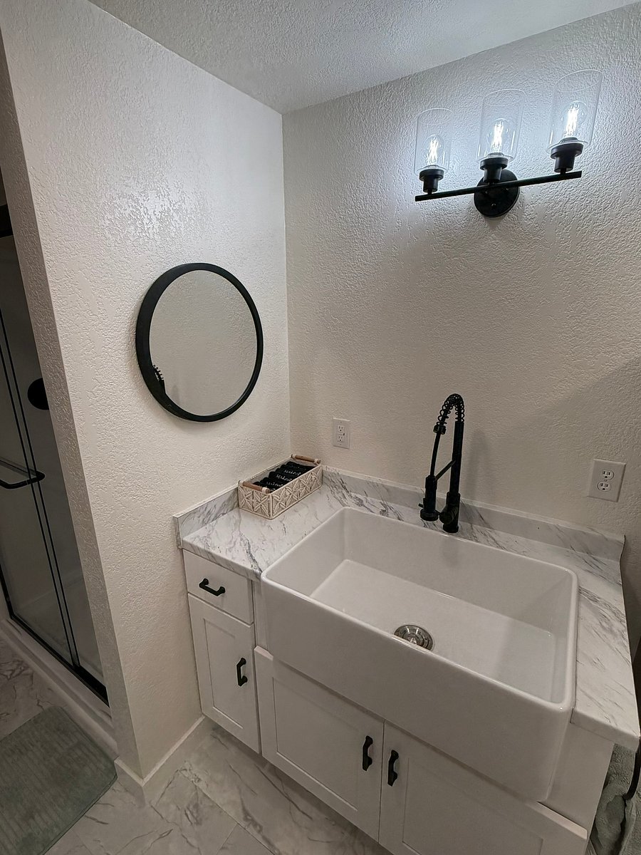 A huge farmhouse sink with an optional grate for washing dishes, plus a great tap with a pull-down head. Thoughtful touches include dish soap, dish scrubbers, makeup towels, and more!