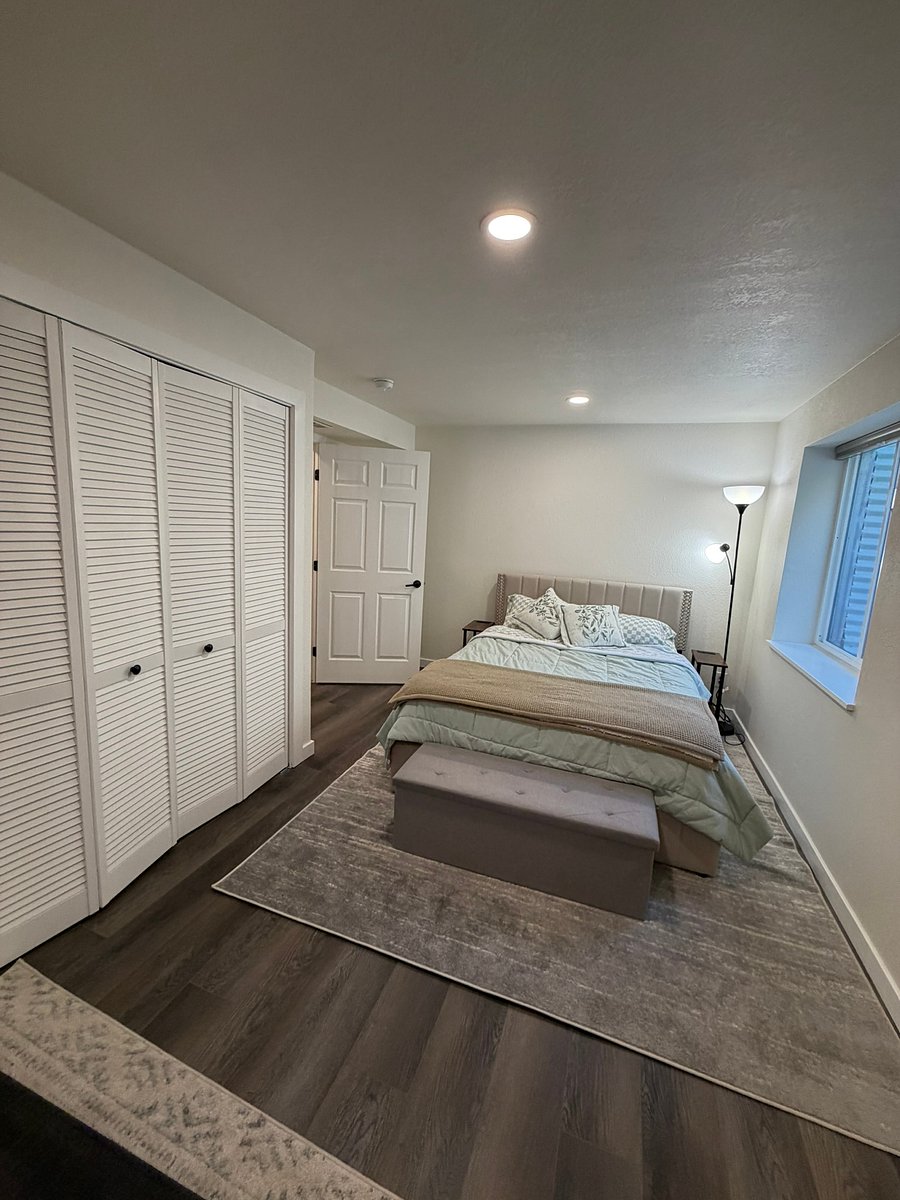Your bedroom space, with a memory foam bed and pillows, an optional memory foam topper, and blackout blinds for a great night's sleep. A large wardrobe and storage ottoman are empty apart from a spare blanket, leaving plenty of room for your belongings!