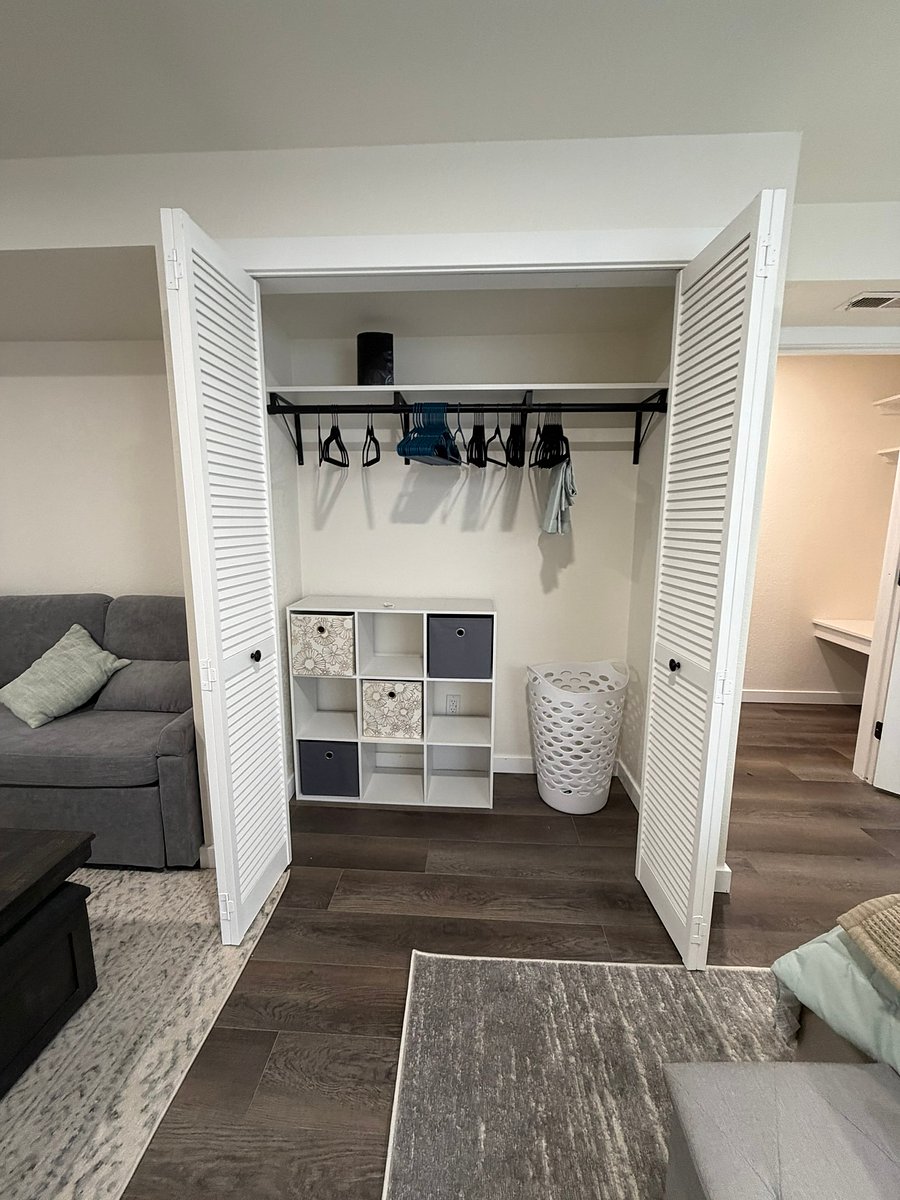 A large wardrobe with tons of hangers, drawers, and a laundry basket!