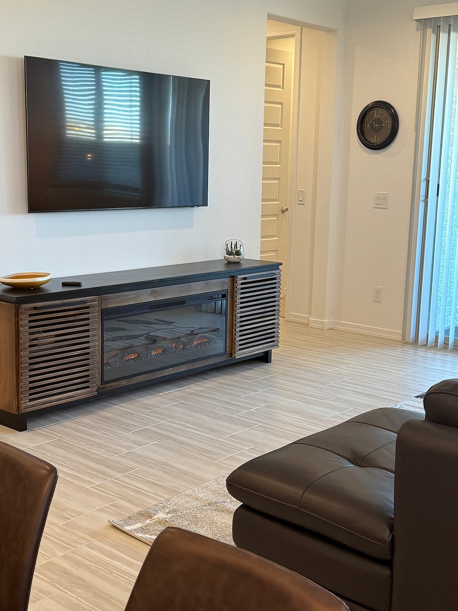 View of smart tv and fireplace and console-- perfect to take the winter chill off!  Sliding door to back yard on the right.
