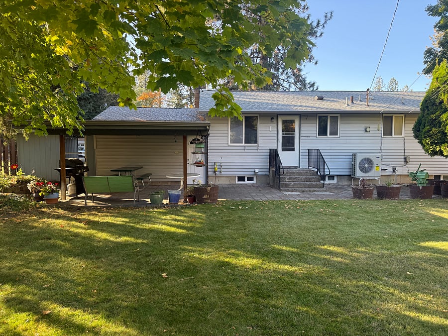 View of home from backyard; covered patio area, BBQ