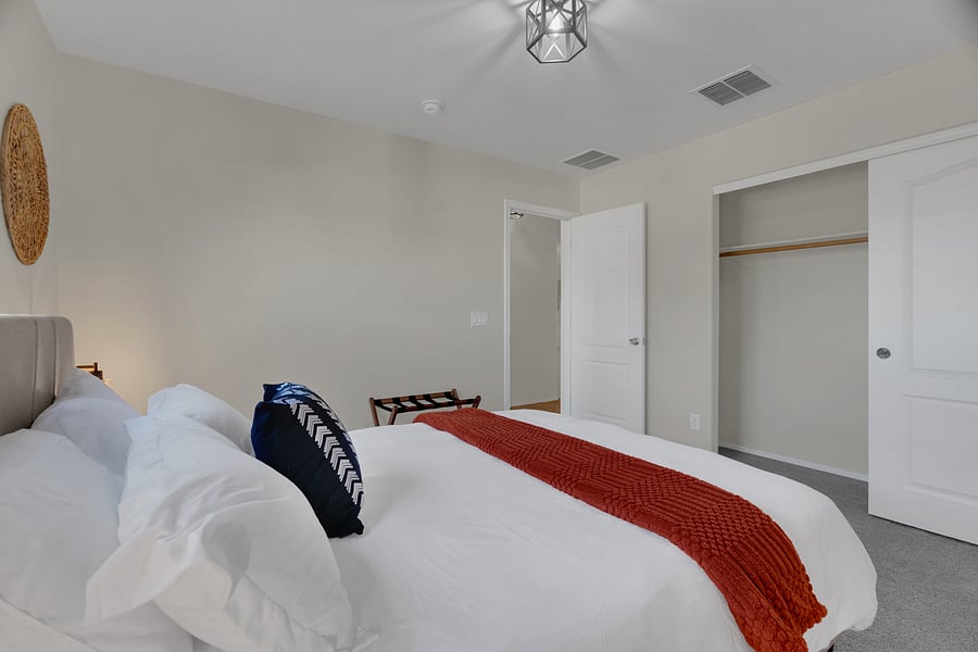 Spacious bedroom with closet storage, hangers and easy access to the hallway and bath.