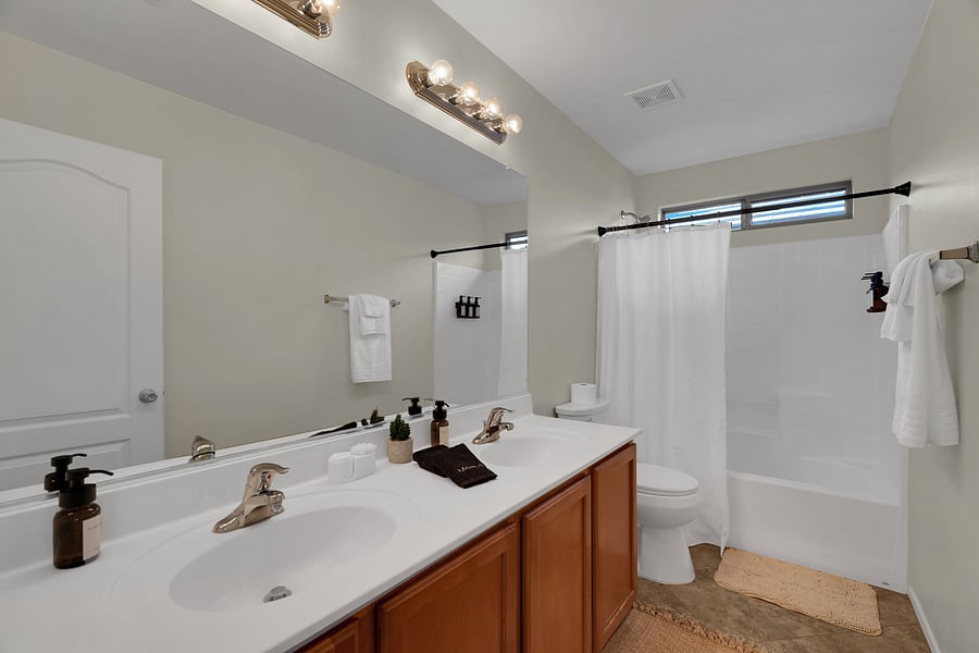 Clean, spacious upstairs bathroom with double vanity and tub/shower combo.