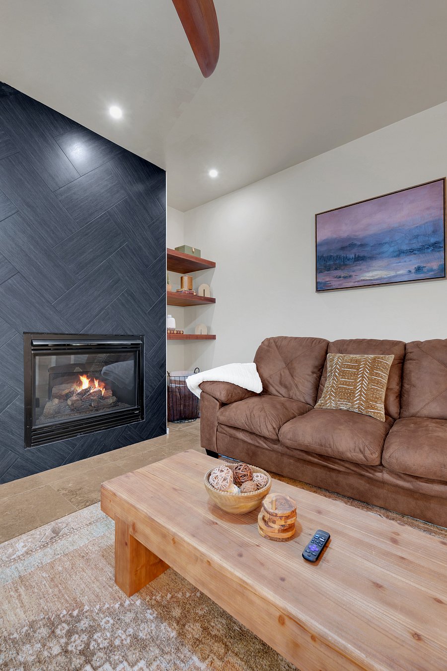 Curl up by the striking herringbone fireplace on a plush sofa, with soft throws and a smart TV ready for movie night.