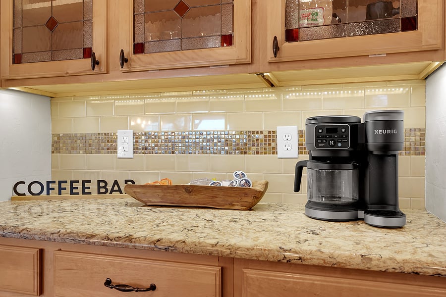 Brew a single cup or a full pot at this charming coffee station, complete with treats and under-cabinet lighting.