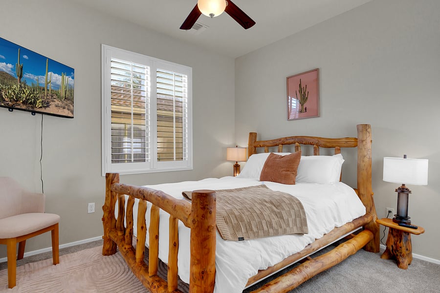 Rustic charm meets comfort in this cozy bedroom, with a handcrafted log bed, crisp white linens, and a wall-mounted smart TV. Located on the main floor for easy access.