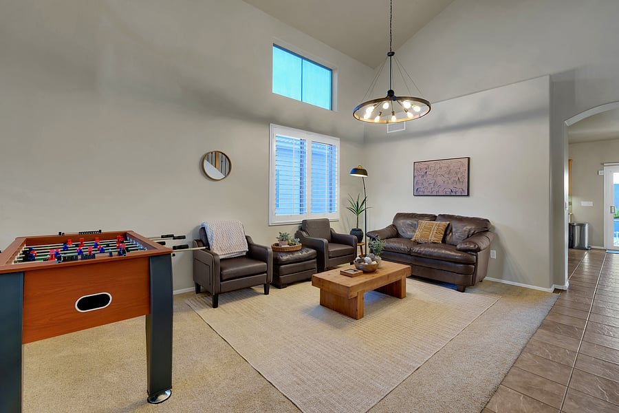 Spacious and stylish, this living room pairs soaring ceilings and comfy leather seating with a foosball table for family fun.
