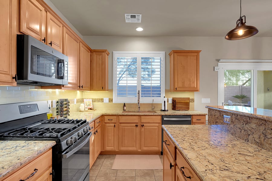 Whip up a feast in this bright, spacious kitchen featuring warm wood cabinetry, a farmhouse-style faucet, and a SMEG toaster.