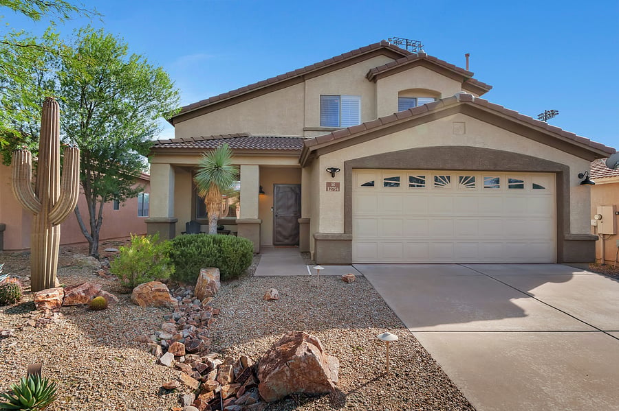Sunny skies and desert charm: a stylish two-story home with a private driveway, two-car garage, and easy, inviting arrival.