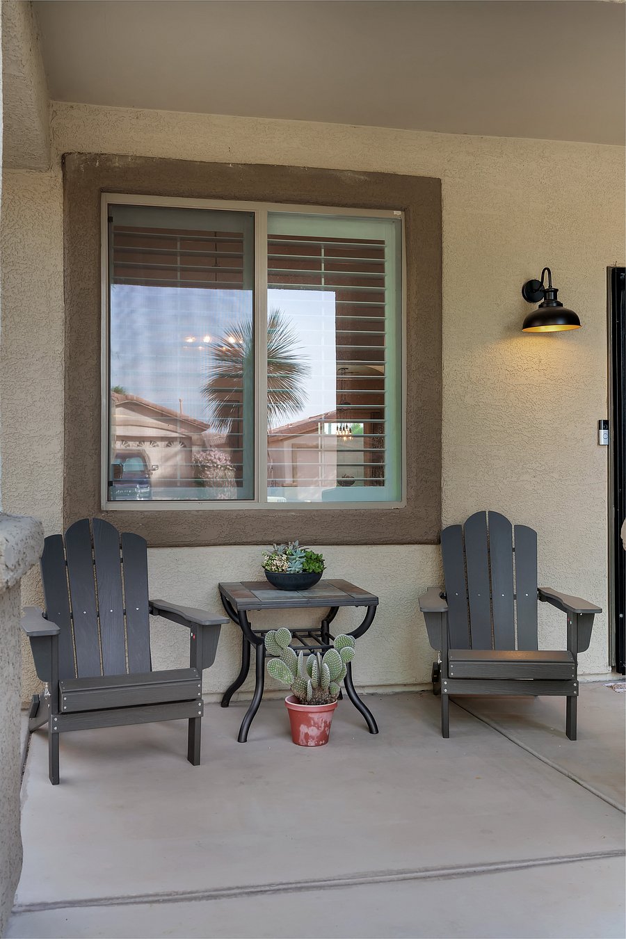 An inviting welcome awaits: a charming covered porch thoughtfully styled for slow mornings and relaxing desert evenings.