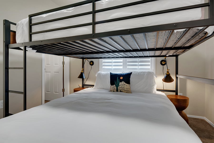 Cozy up in the lower queen with crisp white bedding, personal reading lamps, and sculpted wood nightstands.