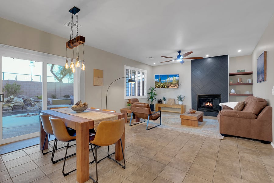 Gather around the farmhouse dining table beneath rustic Edison lighting, steps from the kitchen and backyard grill.